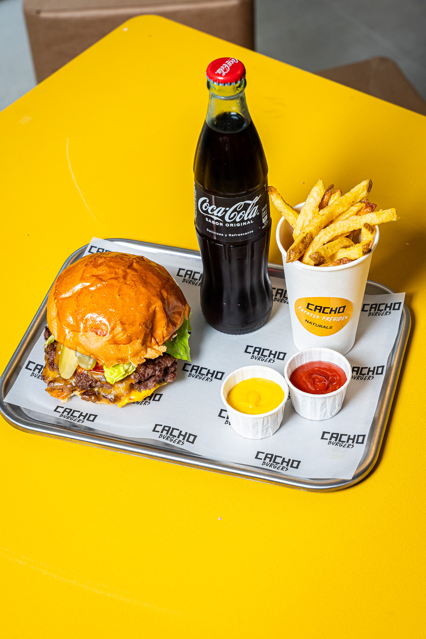 Burger, patatas y bebida en Cacho Burgers